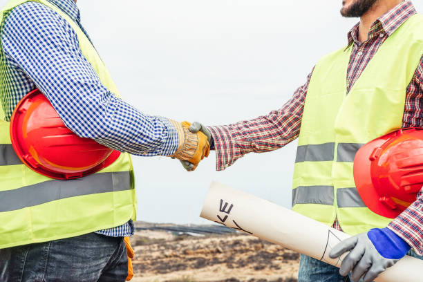 istock Builders shaking hands making an agreement on construction site - Workers reaching a deal on renewable energy project on the working site - Building, dealing, engineer industrial concept 1084532856