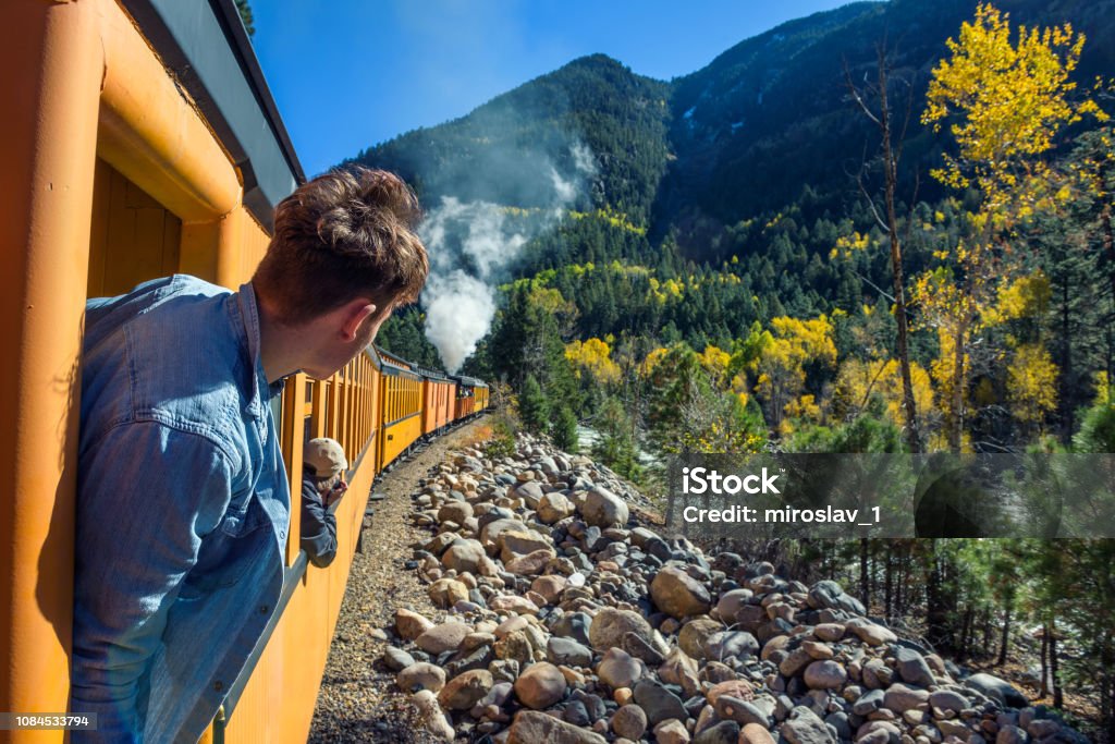 Young man looking out of train window on the historic steam engine