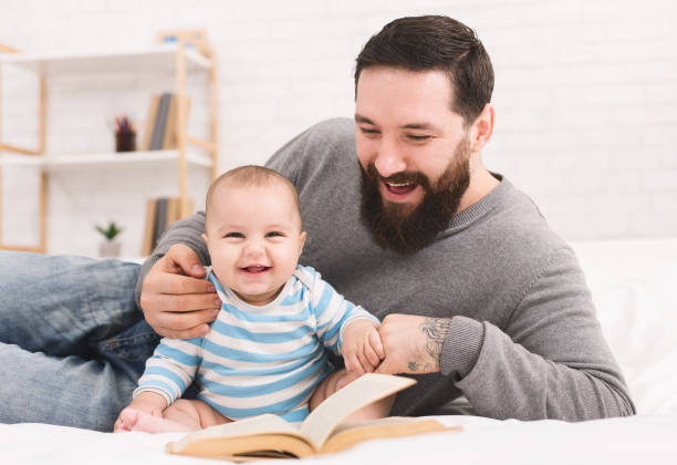 istock Father reading book to little baby son 1084535342
