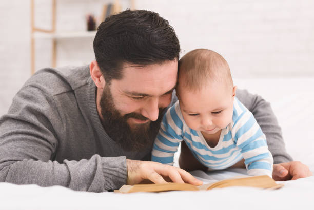 istock Father reading book to little baby son 1084535358