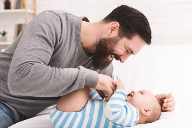 istock Father tickling and snuggling his baby son 1084535372