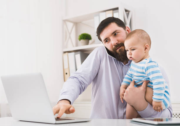 istock Business dad working in office with baby son 1084535420