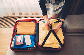 Tourist woman packing the suitcase before leaving