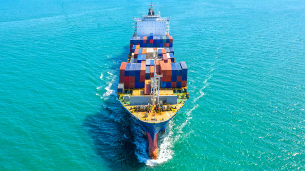 istock Container ship in export and import business logistics and transportation. Cargo and container box shipping to harbor by crane. Water transport International. Aerial view and top view. 1084535832