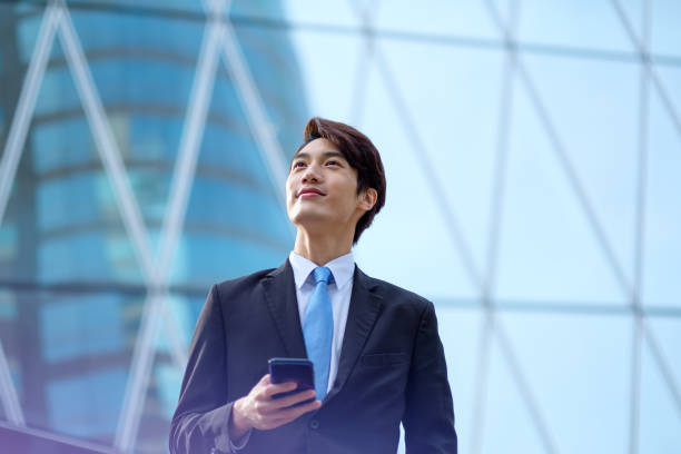 Young businessman using his smartphone on the street stock photo