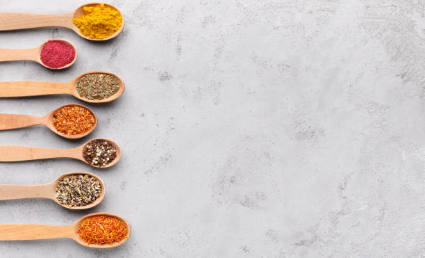 istock Colourful spices in wooden spoons on background 1084550738