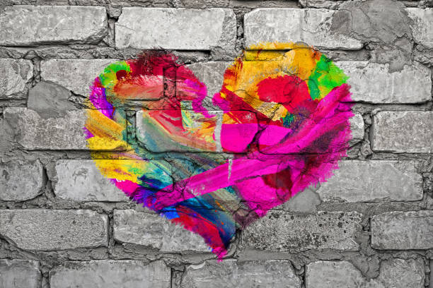 istock Multi colored heart painted on gray brick wall. Love concept 1084551676