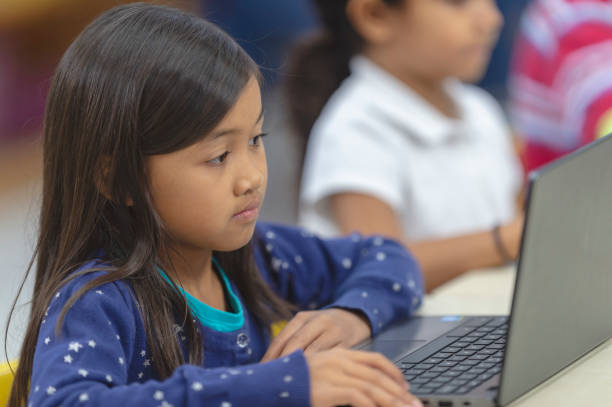 istock Little girl using a laptop in class 1084552566