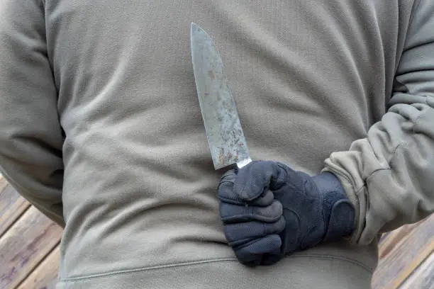 Photo of man wearing black glove and holding knife