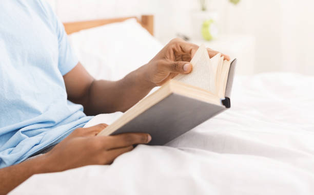 istock Black man studying business literature in bed 1084565864