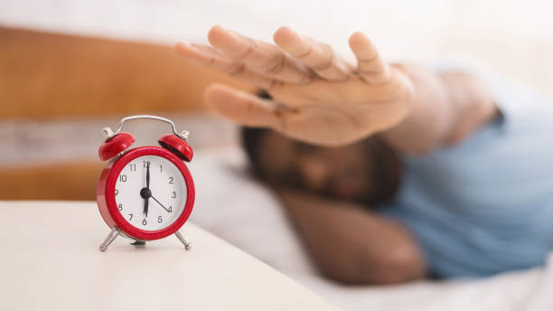 istock Hand turning off alarm clock waking up at morning 1084565894