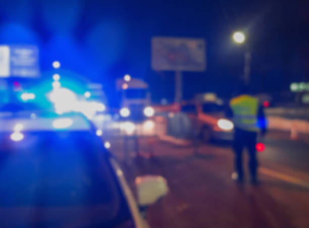 unrecognizable blurry police car lights and police force officer on night road background, crime scene, night patrolling the city. abstract  defocused image. - cidade guarda imagens e fotografias de stock