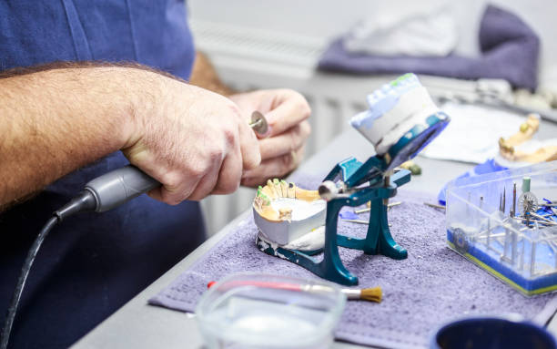 Dental technician working with articulator in dental lab. stock photo