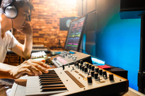 asiático masculino compositor tocando sintetizador de teclado midi para fazer música em estúdio de som - electric mixer sound mixer mixing playing - fotografias e filmes do acervo