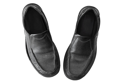 Old dusty black leather Slip-on Shoes for businessman, top view isolated on white background
