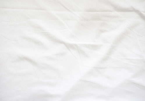 Wrinkle on white bed sheet. Old white bed sheet.