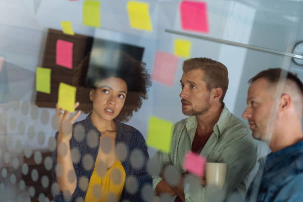istock Coworkers discussing new ideas on a glass wall 1084582314