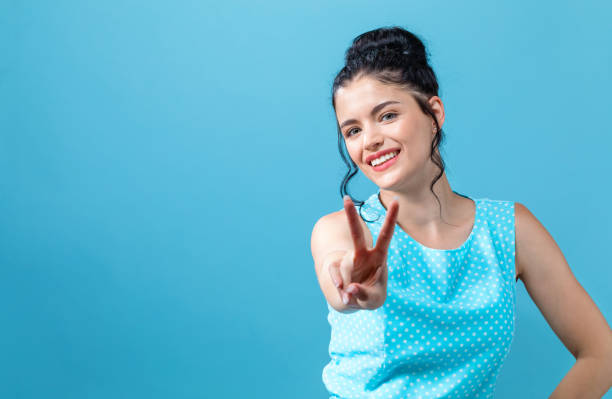 istock Young woman giving the peace sign 1084584716