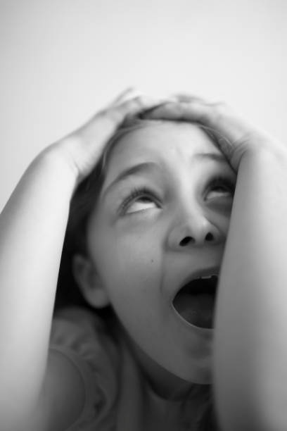 istock Little girl covers her head with her hands and screams 1084586962