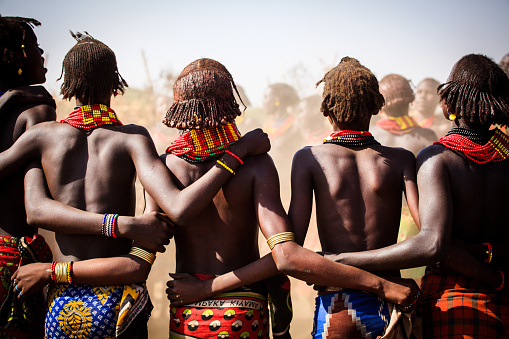 Omorate, Omo River Valley, Ethiopia - 01/05/2018 Group of Dassenech (Dessanech) women hugging each other and chanting while dancing traditional tribal dance in the village
