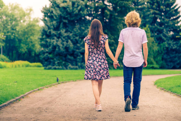 istock Couple walking holding hands in park 1084607600