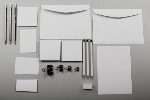 istock A mock up of a template table with a blank envelope, notepad and a cup of coffee with stationery in a gray background. View from above. Flat lay. Layout for the designer. 1084609394