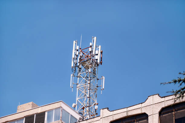 istock Telecommunication base stations network repeaters on the roof of building. The cellular communication aerial on city building roof. Cell phone telecommunication tower. Antennas on top of building. 1084616780