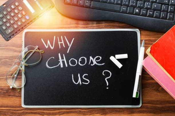 istock why choose us ? question writing with white chalk on blackboard and keyboard, books and calculator, eyeglasses 1084633342