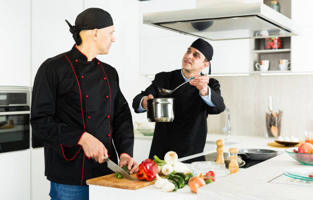 istock Male chefs  in black uniform having quarrel at workplace on kitchen 1084636430