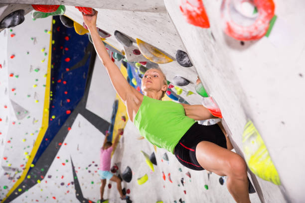 istock Woman climbing artificial rock in gym 1084637180