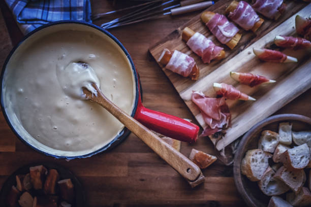 вкусный швейцарский сыр фондю в горшке подается с хлебом - fondue swiss culture winter cheese стоковые фото и изображения