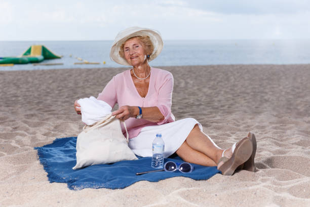 istock Elderly woman relaxing on beach 1084663636