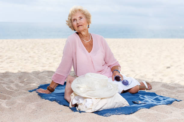 istock Elderly woman relaxing on beach 1084663642