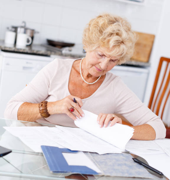 istock Senior woman filling up documents 1084666778