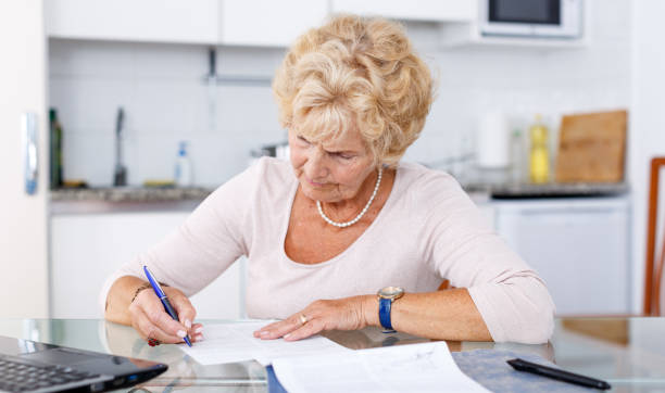 istock Senior woman filling up documents 1084666802