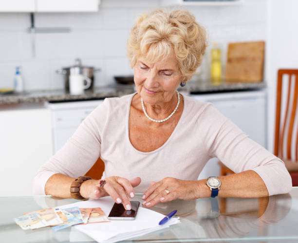 istock Woman counting her expenses using smartphone 1084666824