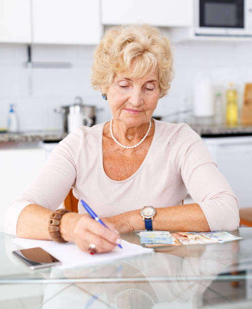 istock Woman counting her expenses using smartphone 1084666832