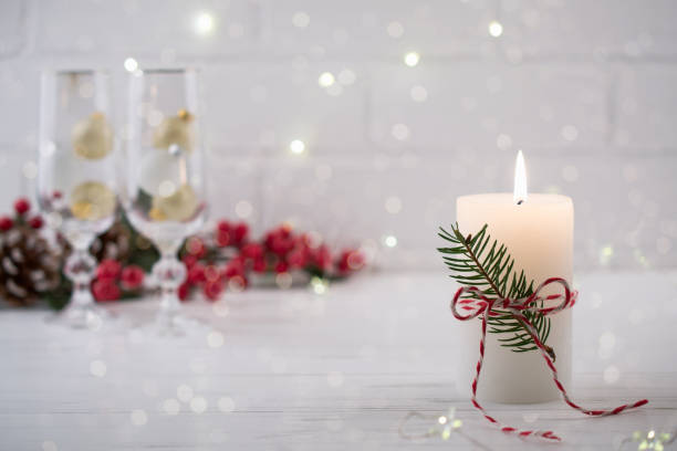istock Christmas home decoration. Burning white candle and Christmas interior red decorations on table 1084668826