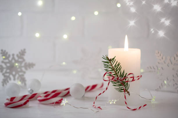 istock Christmas home decoration. Burning white candle and Christmas interior red decorations on table 1084668858