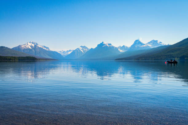 istock Snow capped mountains over blue lake reflection 1084673604