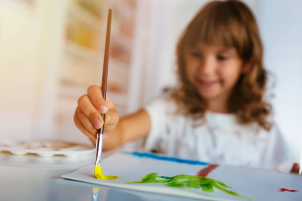 istock Small girl painting with paintbrush 1084674608