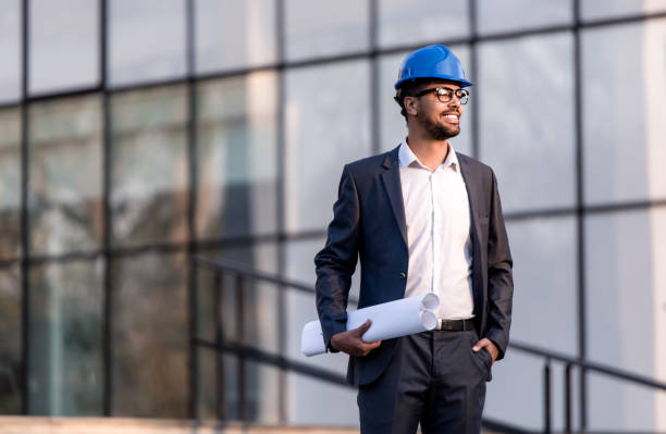istock Happy young African American architect looking at a construction site. 1084675700