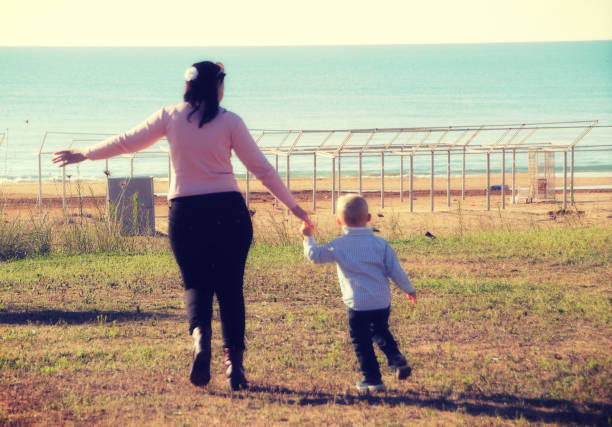 istock mother and son running to the beach 1084681116