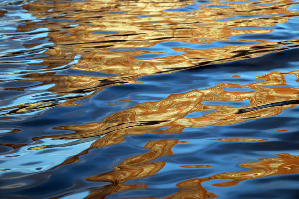 istock Water surface with bright orange reflections in cityscape 1084688600