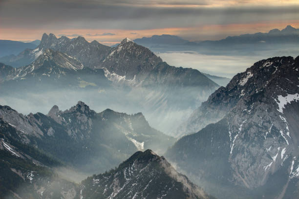istock Sun rays burst through dark clouds over jagged Koschuta Kosuta ridge in Karawanken Karavanke range in autumn morning, Austrian Slovenian border Carinthia Carniola Central Europe 1084690300