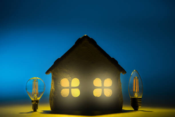 silueta de led lámparas de diseño de la casa sobre un fondo azul - piggy bank savings investment glasses fotografías e imágenes de stock