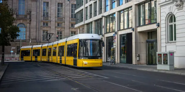 Public transportation concept. Yellow electric tram travels at Berlin's town, Germany. City background, banner.
