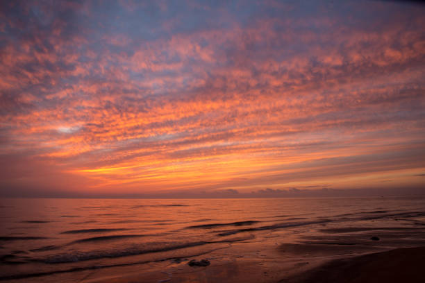 istock dramatic high contrast clouds in sunset over seaside beach 1084694618