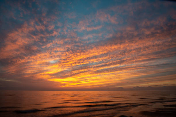 istock dramatic high contrast clouds in sunset over seaside beach 1084694624