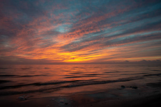istock dramatic high contrast clouds in sunset over seaside beach 1084694630